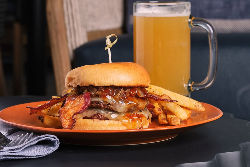 Burger and fries with a beer in the background