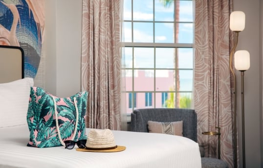 bedroom with a beach bag and sun hat laying on the bed