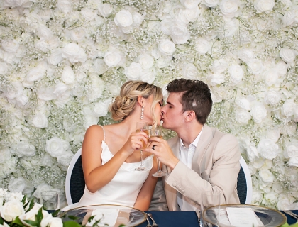 a bride and groom kissing while drinking champagne