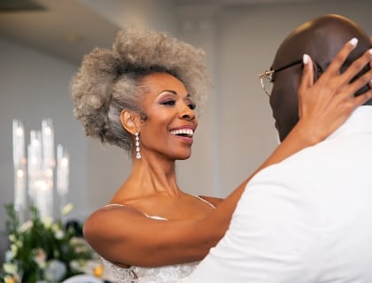 a bride holding her groom while they dance