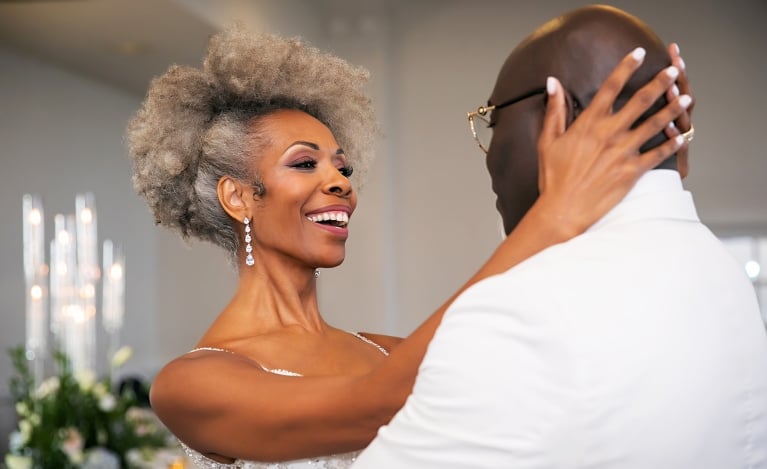 a bride holding her groom while they dance
