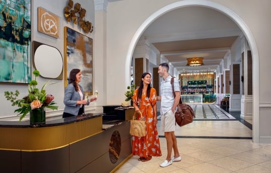 a couple checking in and being handed a glass of champagne