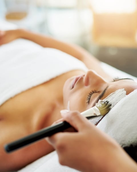 young woman getting a facial at a beauty spa