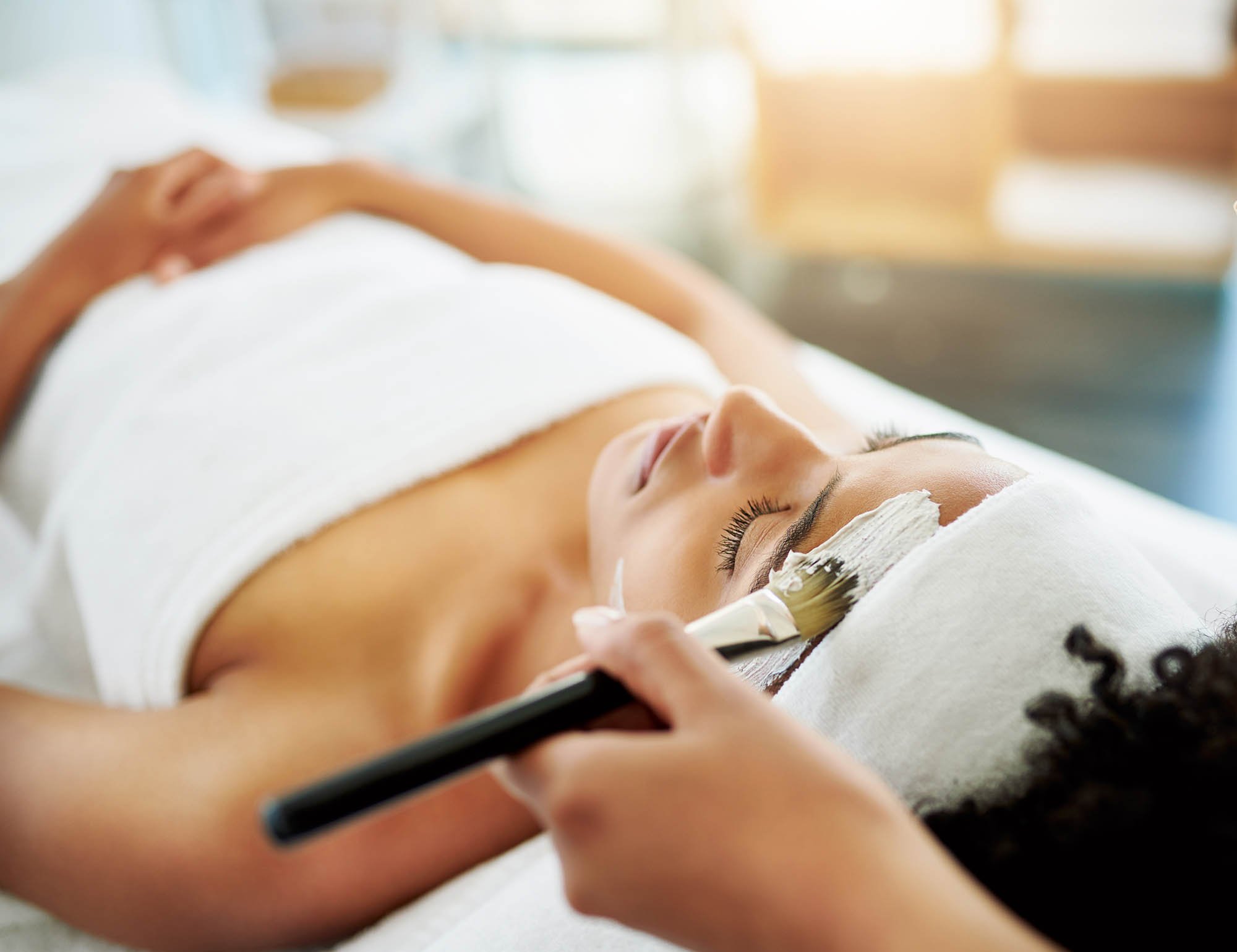 young woman getting a facial at a beauty spa