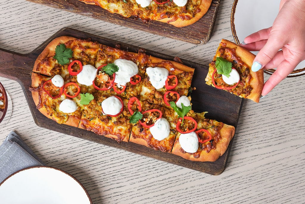 Pizza on a serving board on a table