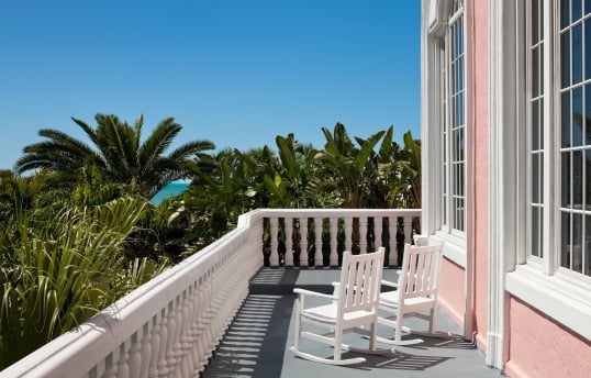two white rocking chairs on a balcony