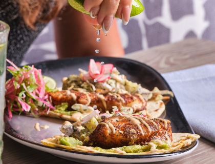 Lime being squeezed on shrimp tacos