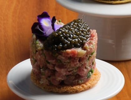 Tartar on a white dish on a wood table