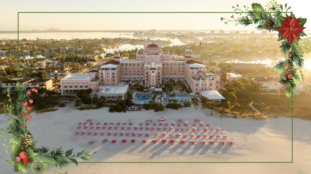 Aerial view of a pink seaside hotel at sunset, with rows of red sun loungers lined on the sand and decorative holiday border corners.